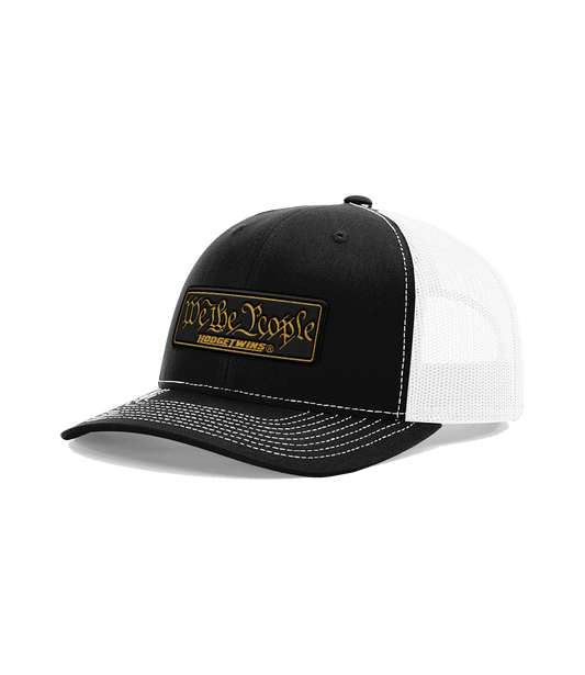 Black front white mesh OSFA mesh hat with a black and gold leather patch that reads We The People
